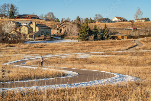 winter afternoon on a meandering biking trail with a distant walker - Cathy Fromme Prairie Natural Area in Fort Collins, Colorado photo