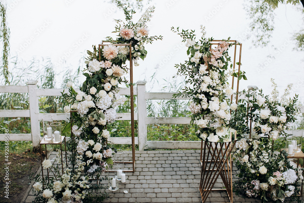 Φωτογραφία Beautiful wedding arch of fresh flowers by the lake