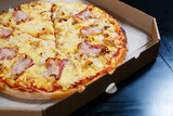 Fresh pizza with cheese in a cardboard craft box, freshly baked pizza