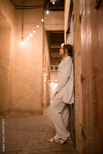 Woman tourist walking in Al Seef Meraas Dubai - old historical district with traditional Arabic architecture © bondvit