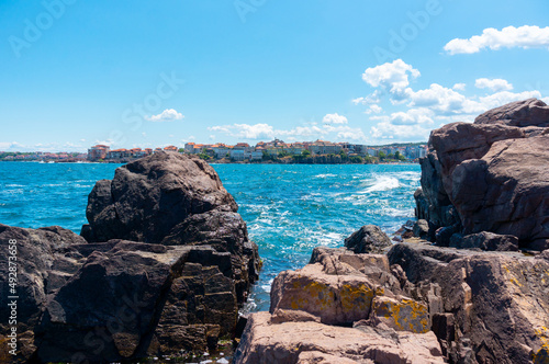 Sea surf day landscape. Sea waves with white foam breaks on stones. Sozopol. Bulgaria