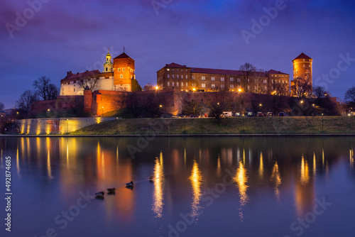 The Wawel Castle of Krakow illuminated at night, reflected on the Vistula River, Poland