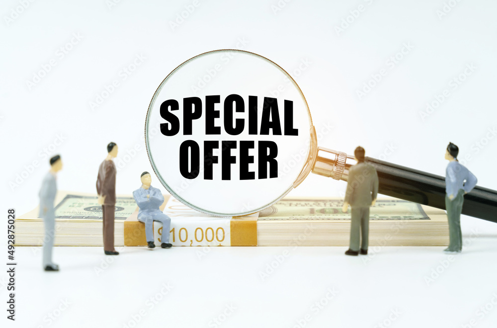 On a white surface, a dollar, figurines of people and a magnifying glass with the inscription - SPECIAL OFFER On a white surface, a dollar, figurines of people and a magnifying glass with the inscription - SPECIAL OFFER