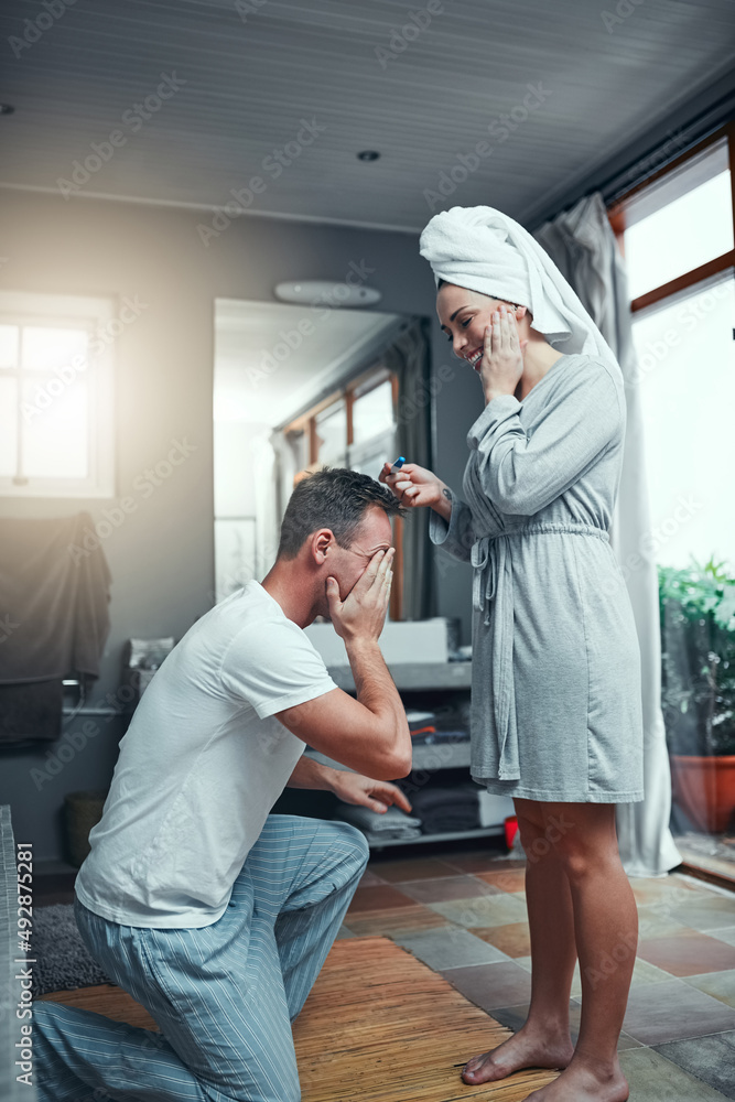 Its a wonderful surprise for them both. Shot of a young couple looking happy after taking a pregnancy test at home. Its a wonderful surprise for them both. Shot of a young couple looking happy after taking a pregnancy test at home.