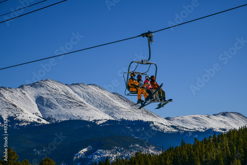 Active sporty lifestyle and winter vacation at Breckenridge Ski Resort in Colorado. People riding chairlift to the peak of the mountain on a beautiful sunny day. photo