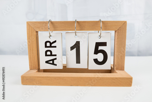 April 15, wooden calendar on a white table.
