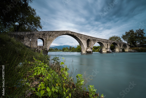 Stone arch bridge over river in Arta city, Greece.