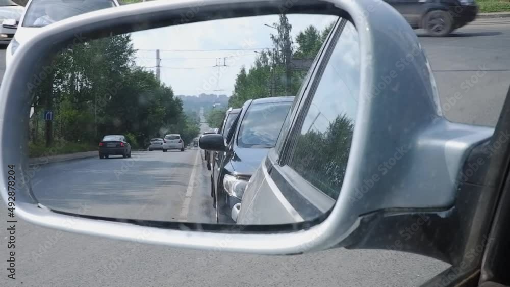 Reflection of cars in the mirror of a passenger car standing in traffic on a hot day Reflection of cars in the mirror of a passenger car standing in traffic on a hot day