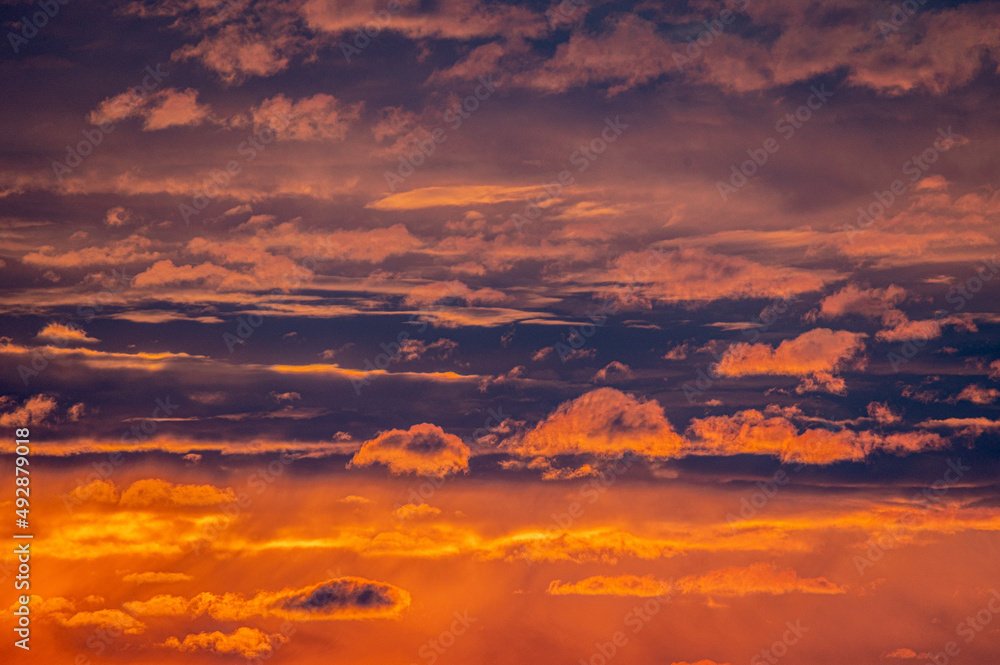 Wolken die vom Sonnenuntergangslicht stark rot-orange angestrahlt werden