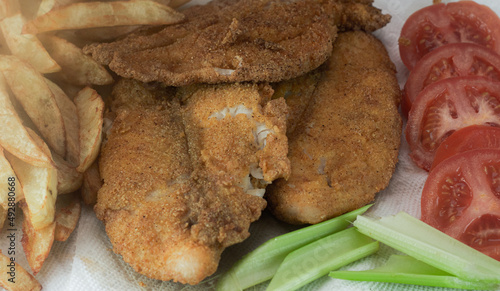 Catfish and french fries with side vegetables