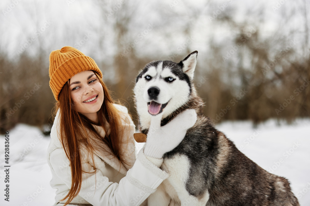 portrait of a woman outdoors in a field in winter walking with a dog winter holidays portrait of a woman outdoors in a field in winter walking with a dog winter holidays