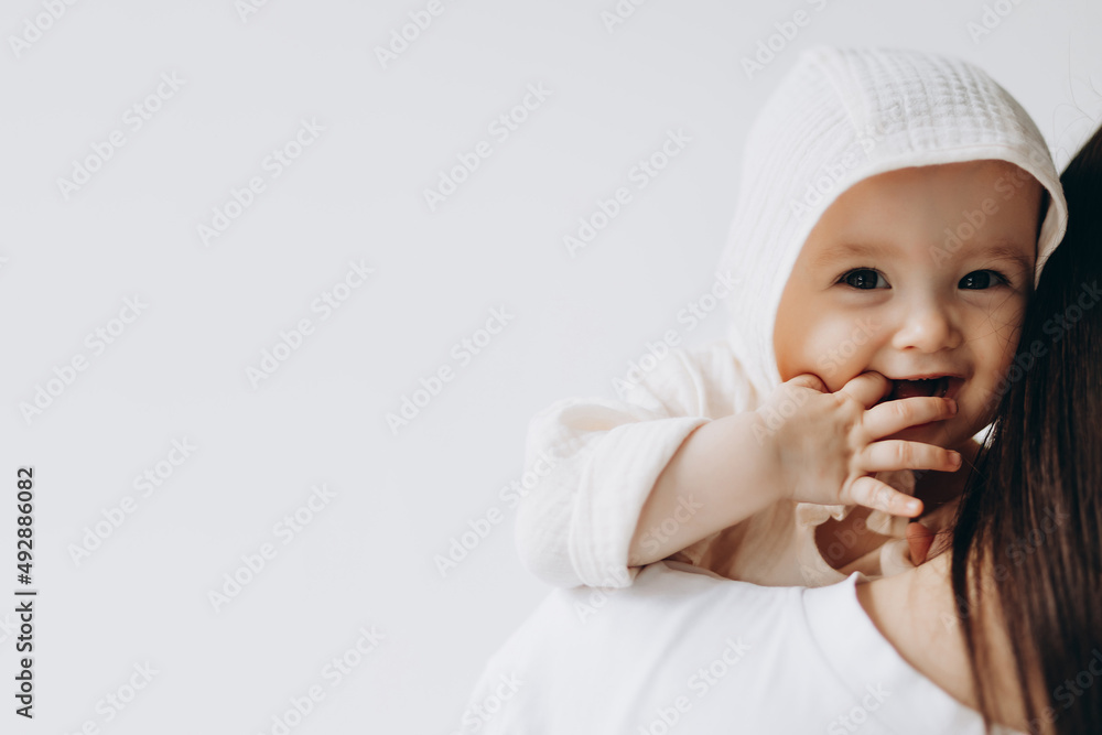 cute studio portrait of a little newborn girl posing for a photo in her mother's arms
