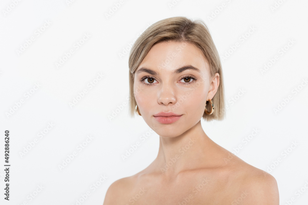 Blonde woman with naked shoulders looking at camera isolated on grey. Blonde woman with naked shoulders looking at camera isolated on grey.