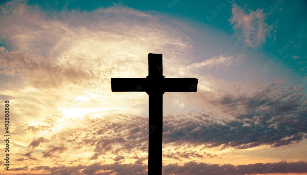 The wooden Cross at the sunset sky background