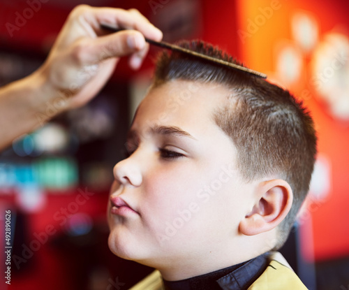 Looking good. Closeup shot of a young boy getting a haircut at a barber shop. photo