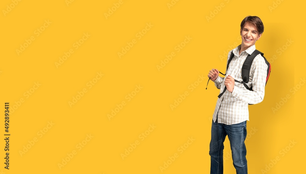 Young male student with backpack posing on background Young male student with backpack posing on background