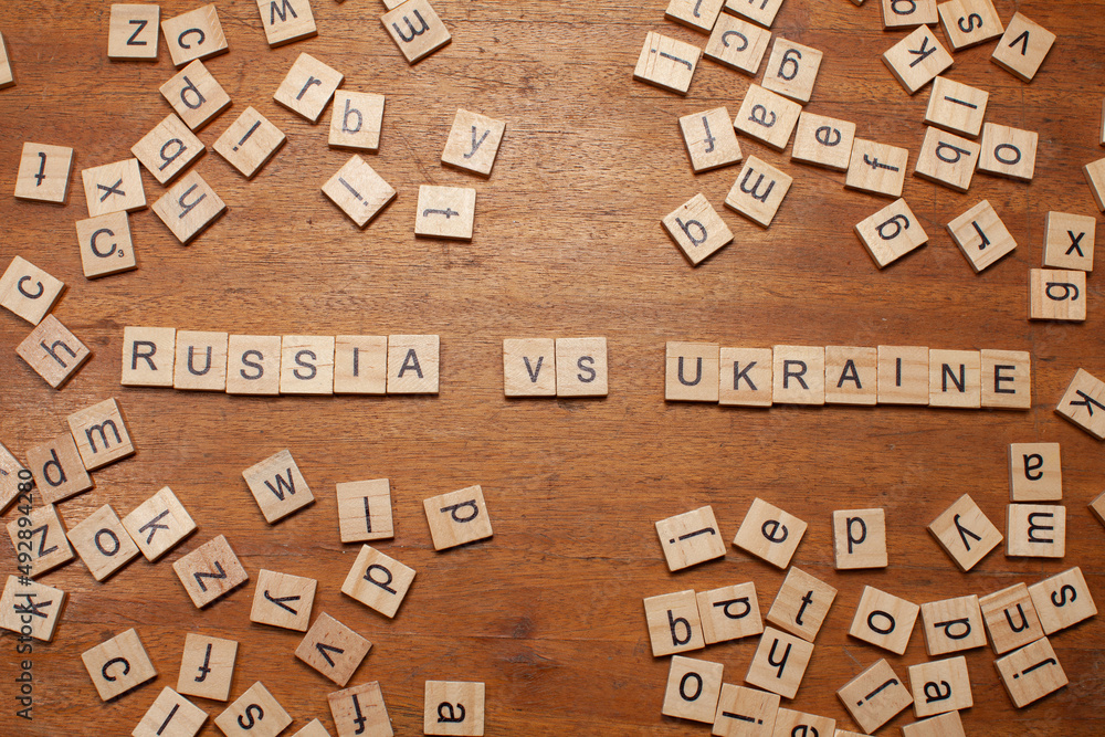 russia vs ukraine letters on wooden background