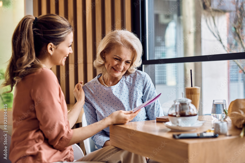 Happy senior woman receiving greeting card from her daughter on Mother's day. Happy senior woman receiving greeting card from her daughter on Mother's day.