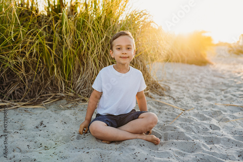 Young boycotting in sand at sunset photo