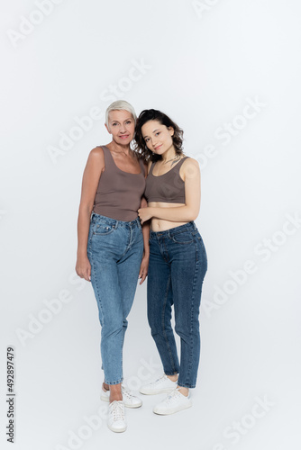 Smiling women looking at camera on grey background, feminism concept.
