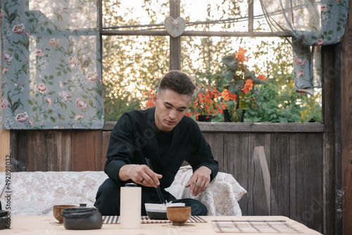 Young asian man dines noodles in a restaurant