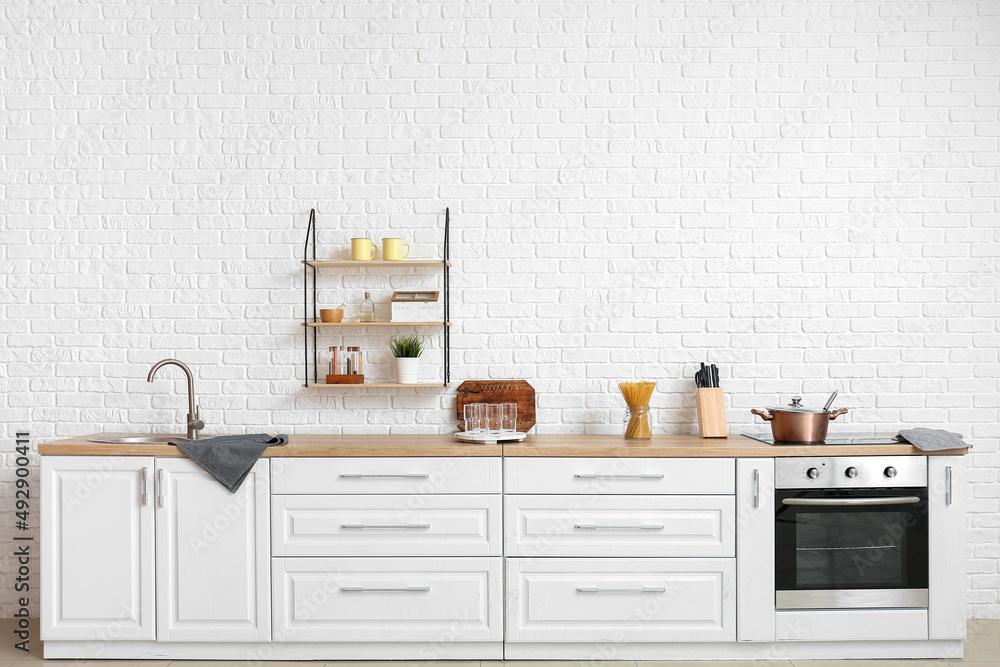 Interior of modern kitchen with white counters and empty glasses Stock ...