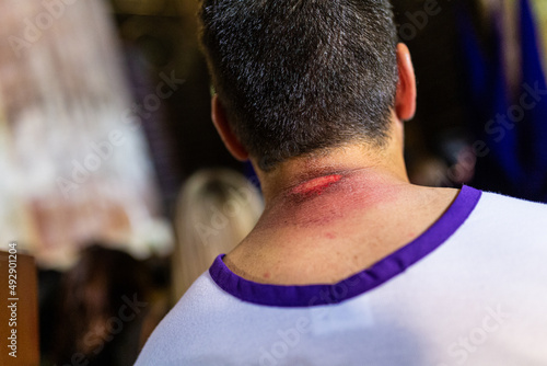 Procession of the Holy Week of Seville. Costalero of the brotherhood of the three falls with the wound in the neck after making the penitential station. High quality photo horizontal photo