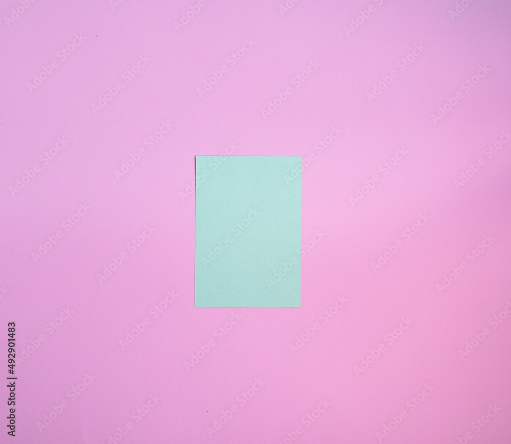 Green paper note over a pink background. Reminder paper Green paper note over a pink background. Reminder paper