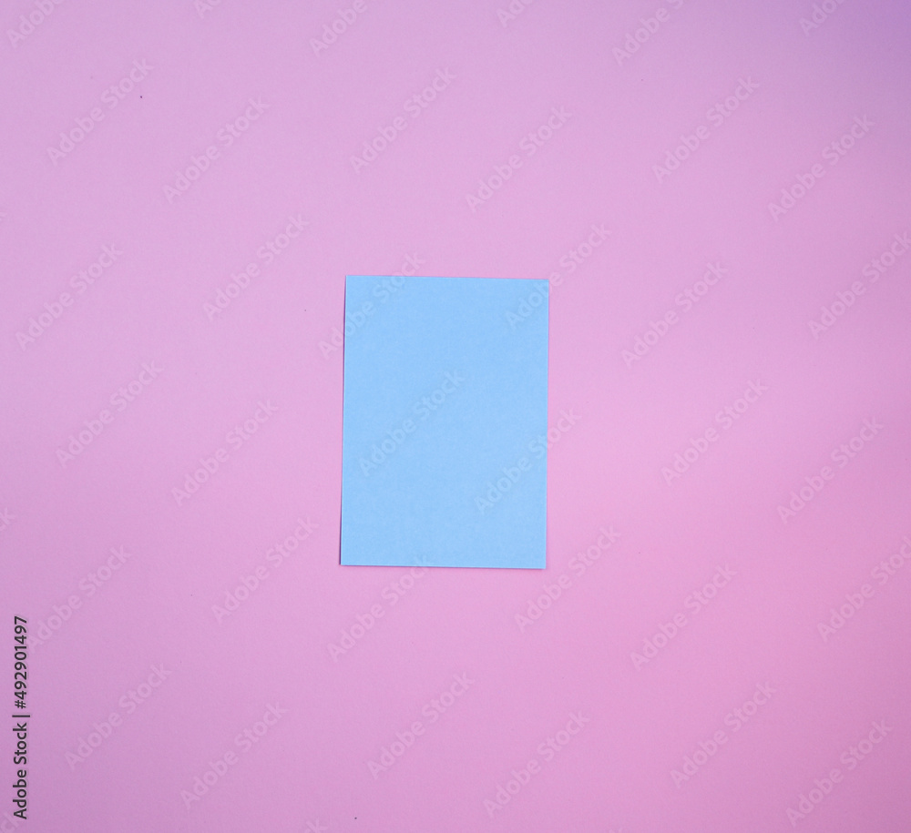 Blue paper note over a pink background. Reminder paper Blue paper note over a pink background. Reminder paper