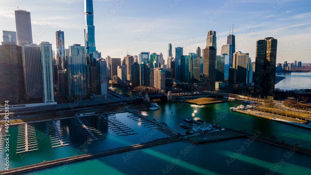 Fototapeta premium Chicago, IL USA- march 13th 2022: aerial drone shot of downtown Chicago by the river during early spring summer. the beautiful skyscrapers look futuristic along the green lake water