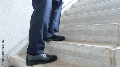 階段をのぼるスーツのビジネスマン イメージ