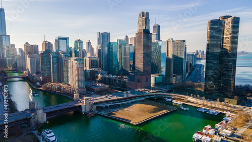 Chicago, IL USA- march 13th 2022: aerial drone shot of downtown Chicago by the river during early spring summer.  the beautiful skyscrapers look futuristic  along the green lake water © ezellhphotography