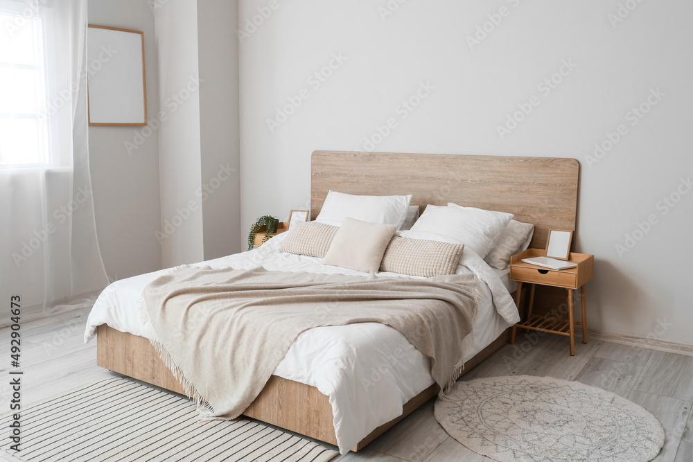 Comfortable bed and nightstands in room - obrazy, fototapety, plakaty 