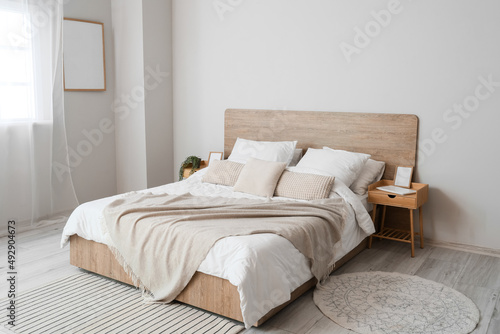 Fototapeta Comfortable bed and nightstands in room