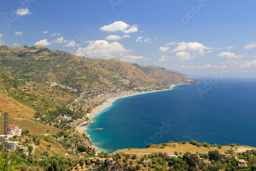 Fototapeta Naklejka Na Ścianę i Meble -  A beautiful view from Taormina Sicily looking at the beach and ocean is the perfect spot for traveller and tourists to enjoy their vacation