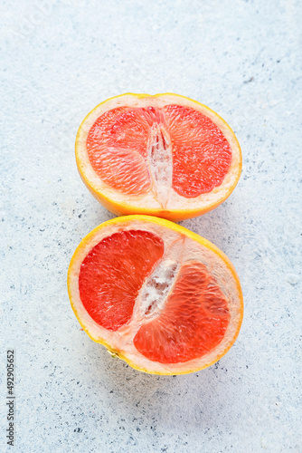 Tasty cut grapefruit on light background