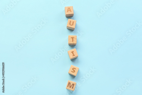 Wooden cubes with word AUTISM on blue background