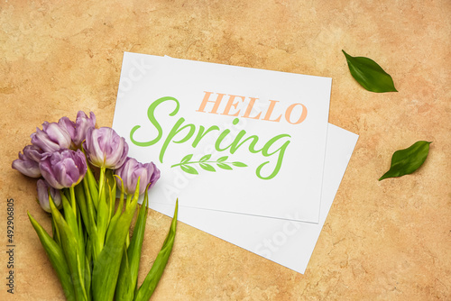 Card with text HELLO SPRING and tulip flowers on color background