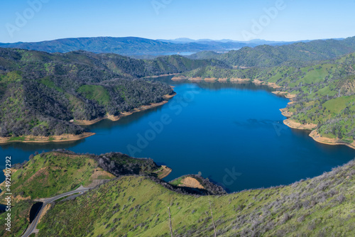 Aerial vew of Lake Berryessa from the Blue Ridge Trail on a sunny day, featuring the reservour and the surrounding blue oak woodland