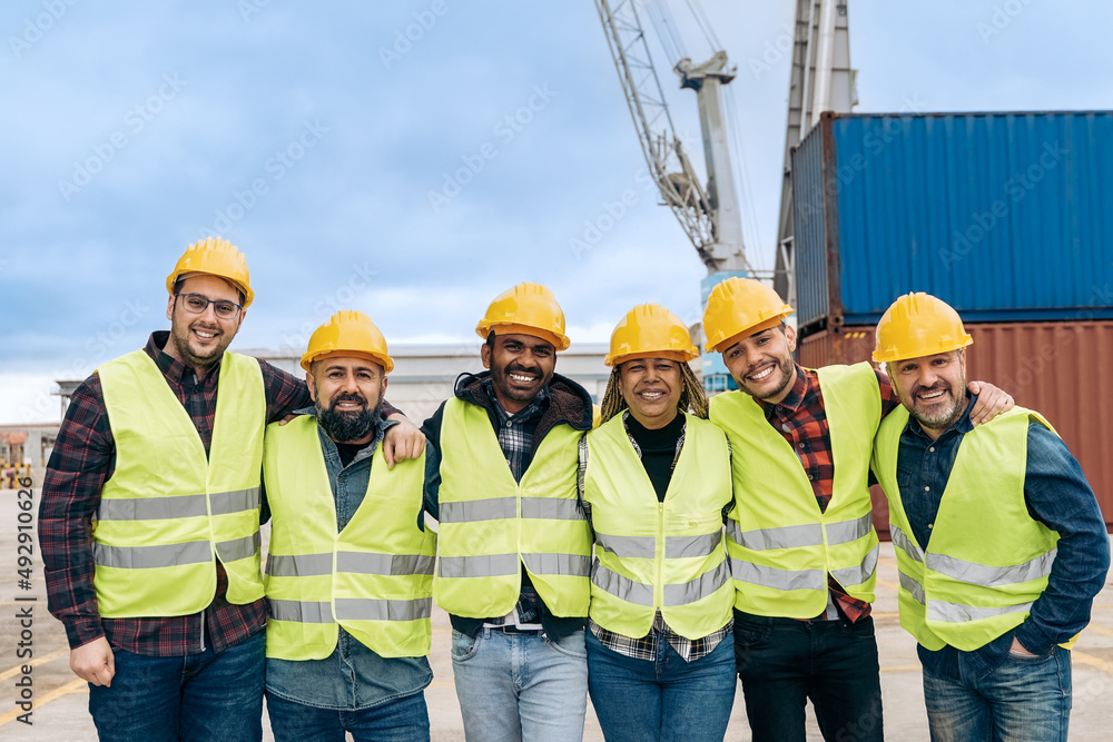 Multiracial worker people having fun inside container cargo terminal at maritime port - Main focus on indian man face Multiracial worker people having fun inside container cargo terminal at maritime port - Main focus on indian man face