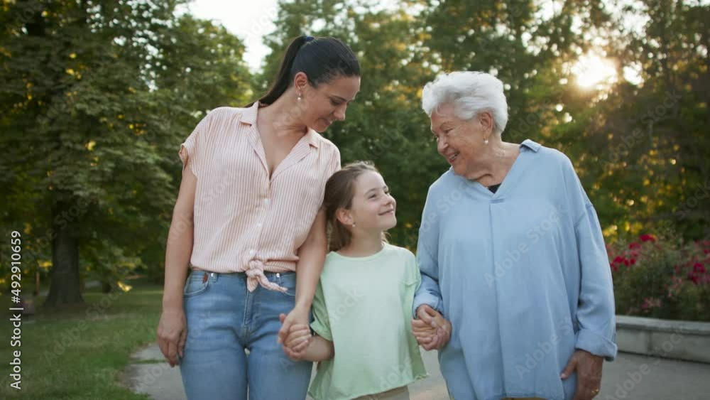 Small girl with mother and grandmother in a park, walking in park. Small girl with mother and grandmother in a park, walking in park.