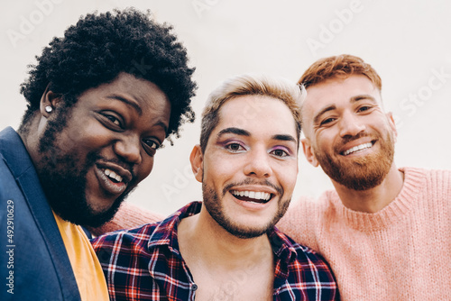 Diverse friends having fun together doing selfie outdoor - Focus on gay male face wearing makeup photo