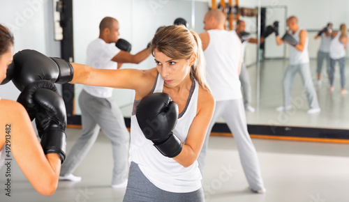 Two diligent efficient women boxing sparring in the gym