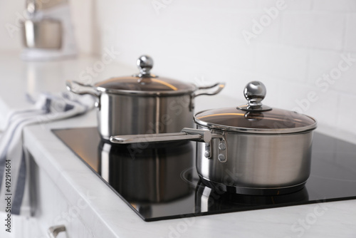 New clean pot and saucepan on cooktop in kitchen photo
