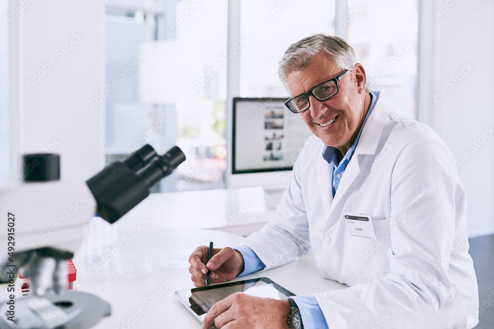 My research could change the future. Portrait of a mature scientist working on a digital tablet in a lab. My research could change the future. Portrait of a mature scientist working on a digital tablet in a lab.