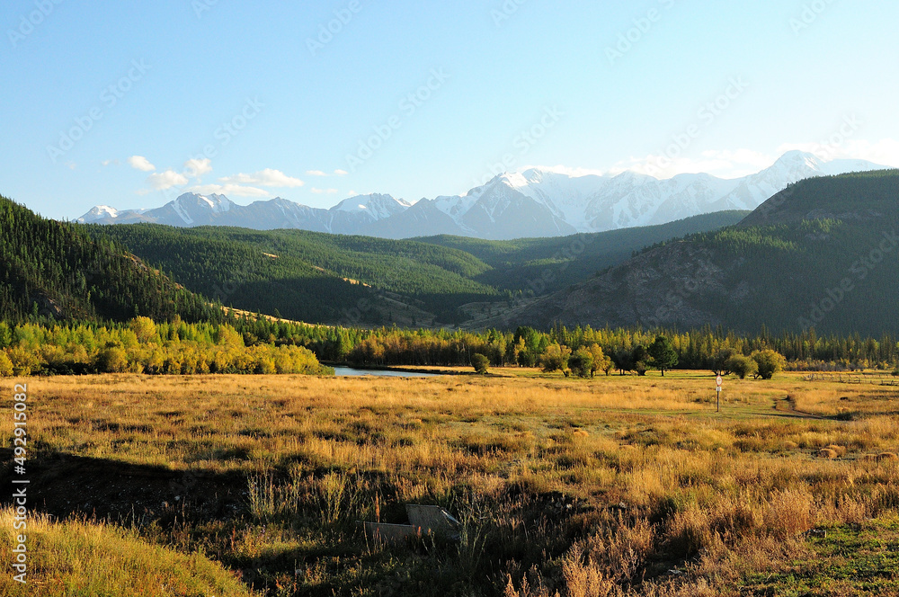 Obraz premium A look across a shallow lake lying on the slopes of the hills overlooking the snow-capped mountains.