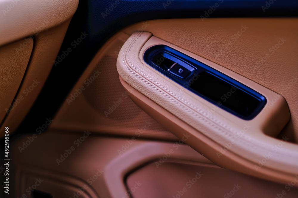 Obraz premium Luxury car beige colour leather interior details with power button to open window and side speaker. Car interior background and design element.