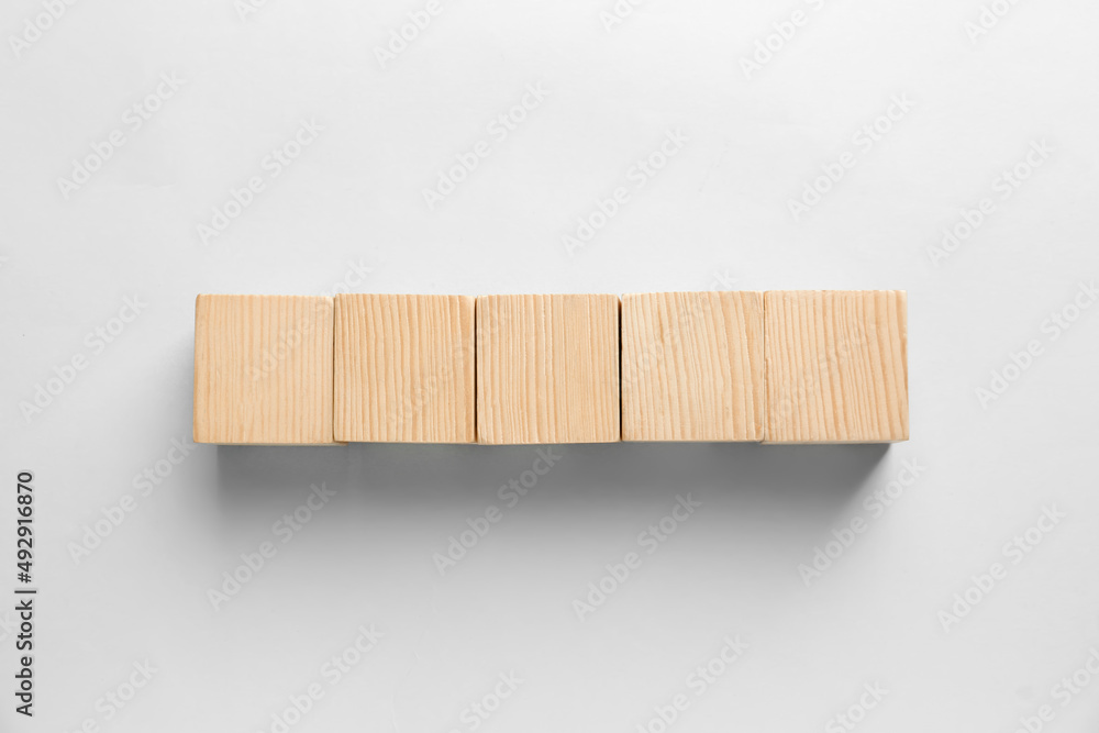 Blank wooden cubes on light background, flat lay. Space for text Blank wooden cubes on light background, flat lay. Space for text