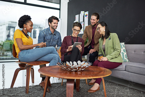 Working hard and dreaming big. Shot of a group of creative businesspeople looking at something on a tablet. © Adene S/peopleimages.com