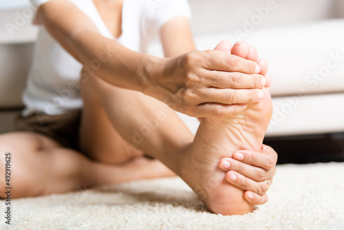 Photo Foot pain, Asian woman feeling pain in her foot at home, female suffering from f